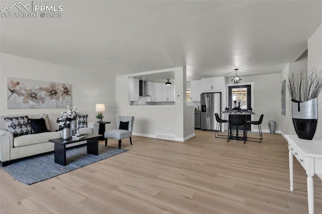 living room featuring a notable chandelier and light hardwood / wood-style flooring