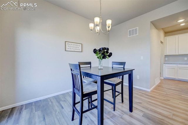 dining room featuring an inviting chandelier and light wood-type flooring