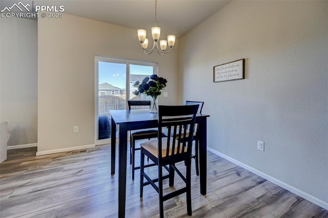 dining space featuring a notable chandelier and light wood-type flooring