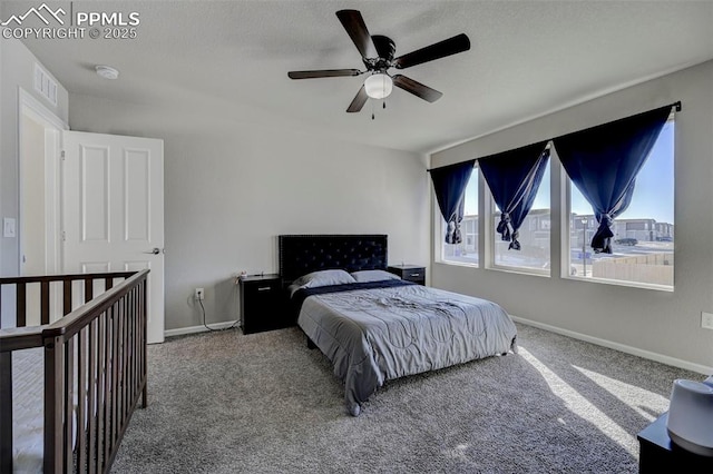 carpeted bedroom with ceiling fan and a textured ceiling