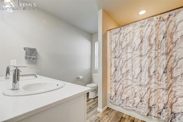 bathroom featuring walk in shower, vanity, toilet, and hardwood / wood-style floors