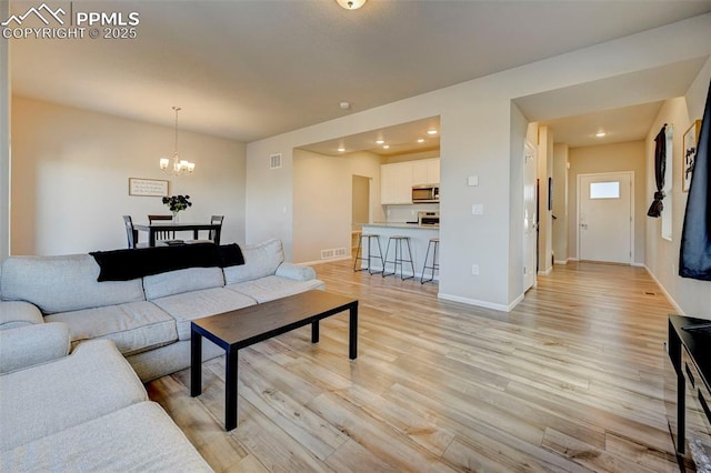 living room featuring an inviting chandelier and light wood-type flooring