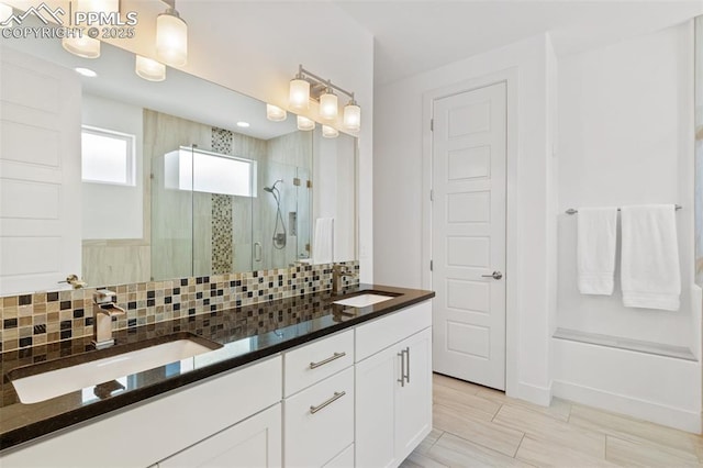 bathroom featuring backsplash, walk in shower, and vanity