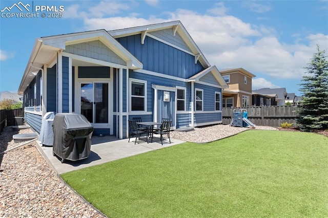 back of house with a playground, a patio area, and a lawn