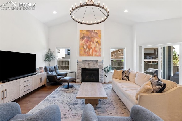 living room featuring a wealth of natural light, dark hardwood / wood-style flooring, a chandelier, and a fireplace