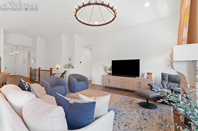 living room with vaulted ceiling, an inviting chandelier, and wood-type flooring