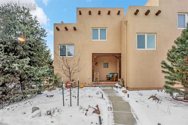 view of snow covered back of property