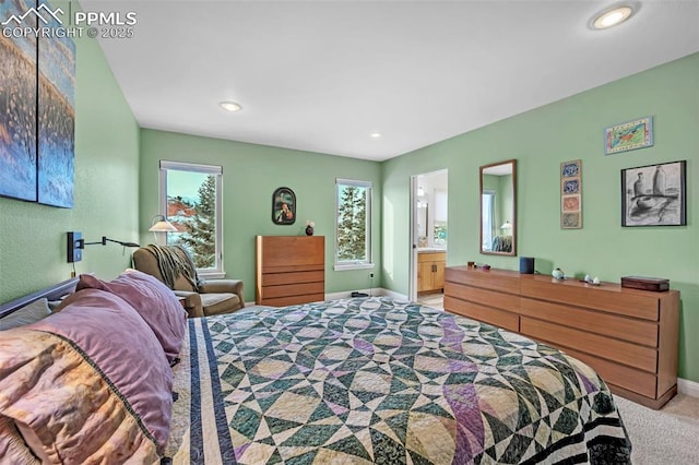 bedroom featuring light carpet and connected bathroom