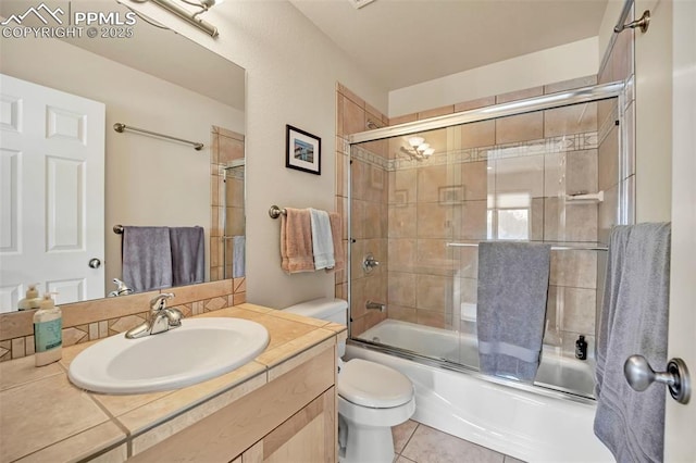 full bathroom with vanity, toilet, bath / shower combo with glass door, and tile patterned floors