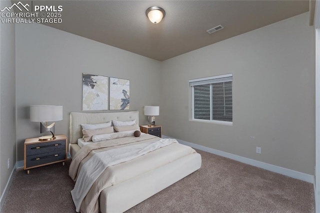 bedroom with dark colored carpet and baseboards