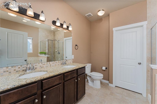 bathroom featuring a shower stall, toilet, double vanity, tile patterned floors, and baseboards