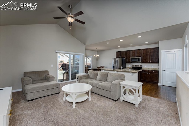 living area with high vaulted ceiling, dark carpet, recessed lighting, a chandelier, and a ceiling fan