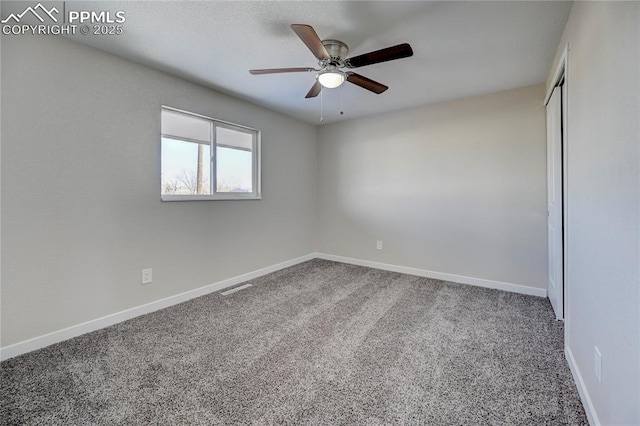 carpeted spare room featuring ceiling fan