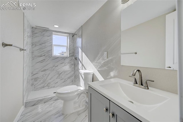 bathroom featuring toilet, vanity, and tiled shower