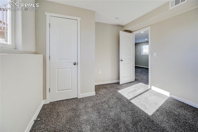 unfurnished bedroom featuring dark colored carpet