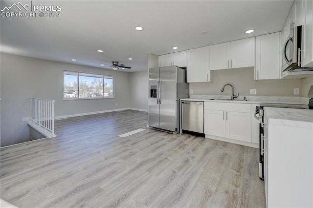 kitchen featuring light hardwood / wood-style floors, white cabinets, appliances with stainless steel finishes, and sink