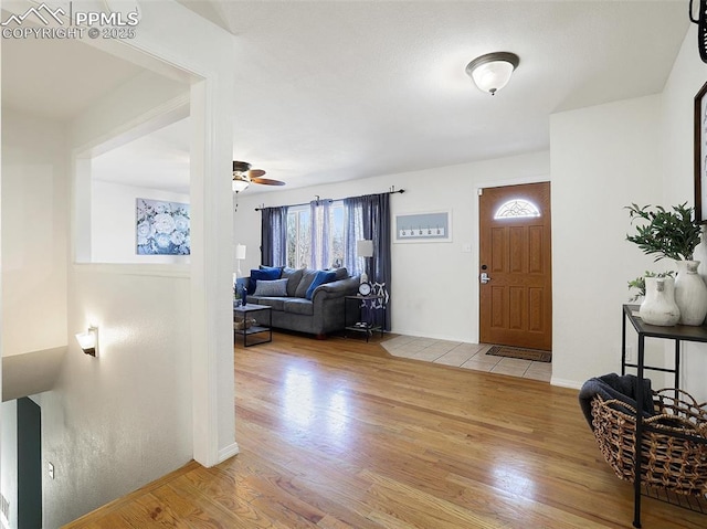 foyer entrance featuring ceiling fan and light wood-type flooring