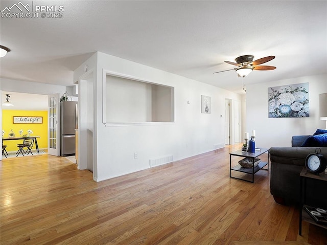 living room with ceiling fan and light hardwood / wood-style floors