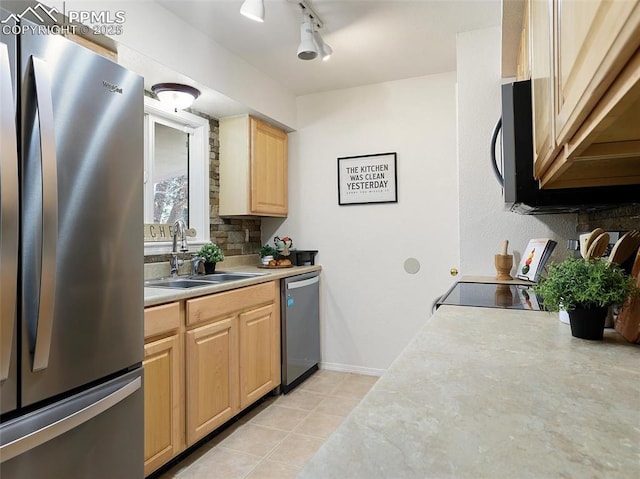 kitchen with appliances with stainless steel finishes, light brown cabinets, sink, rail lighting, and light tile patterned floors