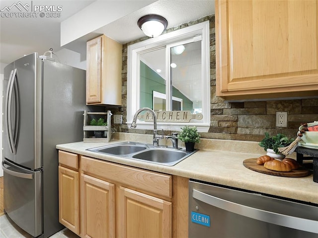 kitchen with light brown cabinetry, appliances with stainless steel finishes, sink, and decorative backsplash