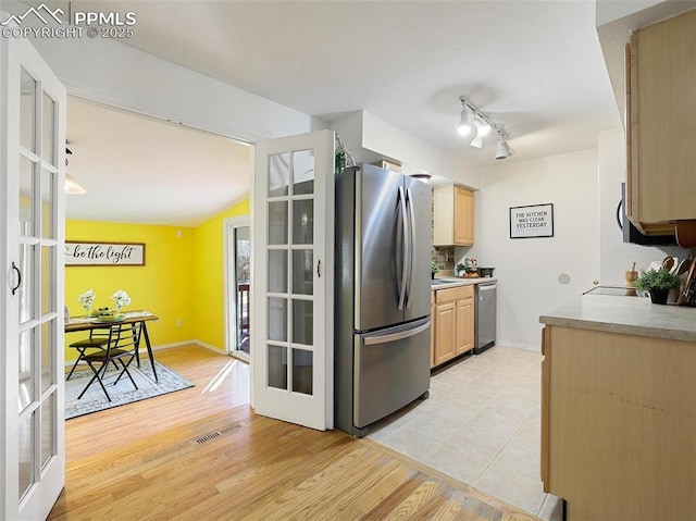 kitchen with light brown cabinetry, light hardwood / wood-style floors, stainless steel appliances, and french doors