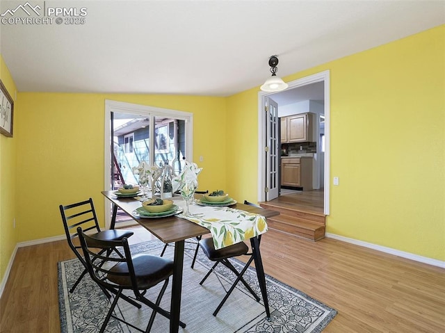 dining area featuring light hardwood / wood-style floors and vaulted ceiling