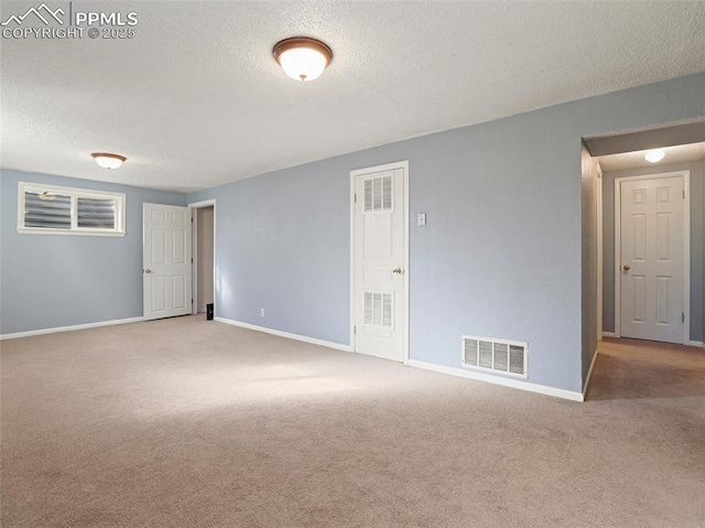 carpeted spare room with a textured ceiling