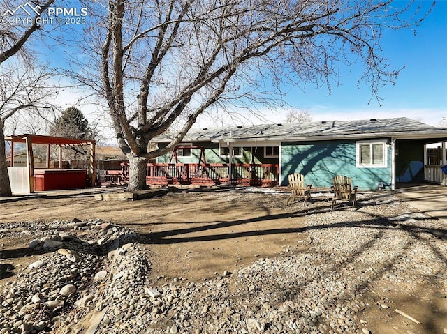 back of house featuring a hot tub