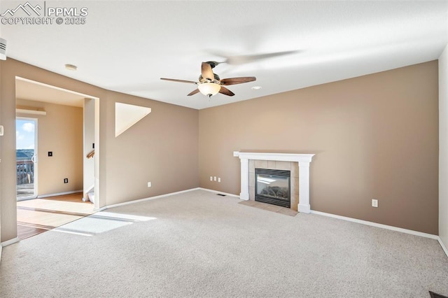 unfurnished living room featuring ceiling fan, light colored carpet, and a fireplace