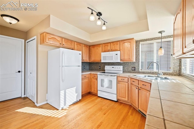 kitchen featuring white appliances, tasteful backsplash, light hardwood / wood-style floors, sink, and hanging light fixtures