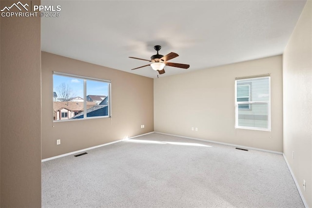 spare room with ceiling fan and light colored carpet