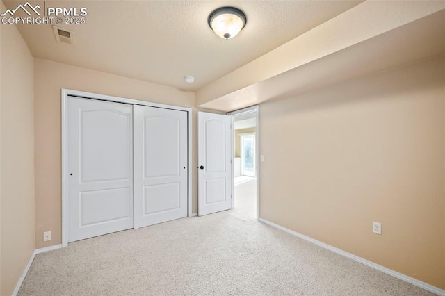 unfurnished bedroom featuring light colored carpet and a closet