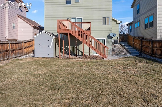 rear view of property featuring a yard, a deck, and a shed