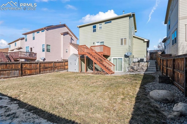 rear view of house featuring a wooden deck, a yard, and a storage shed