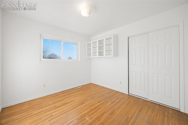 unfurnished bedroom featuring a closet and light hardwood / wood-style floors