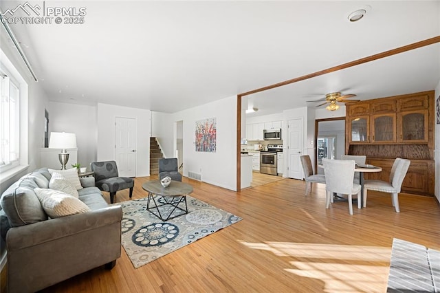 living room featuring ceiling fan and light hardwood / wood-style flooring