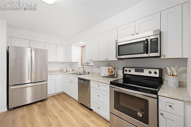 kitchen featuring light hardwood / wood-style floors, sink, white cabinetry, and appliances with stainless steel finishes