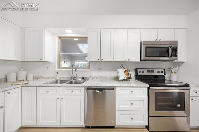 kitchen featuring appliances with stainless steel finishes, white cabinets, and sink