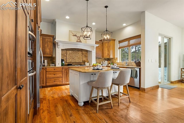 kitchen featuring wood-type flooring, a center island, stainless steel dishwasher, and light stone counters