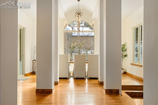 dining room featuring lofted ceiling, a notable chandelier, and light wood-type flooring