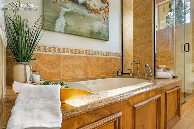 bathroom with tile walls, an enclosed shower, and tile patterned flooring