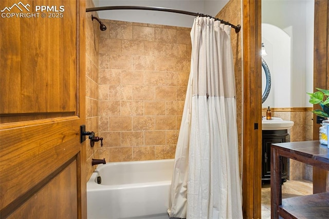 bathroom with tile walls and shower / tub combo with curtain