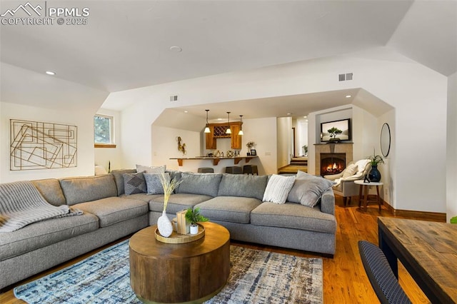 living room featuring lofted ceiling and wood-type flooring