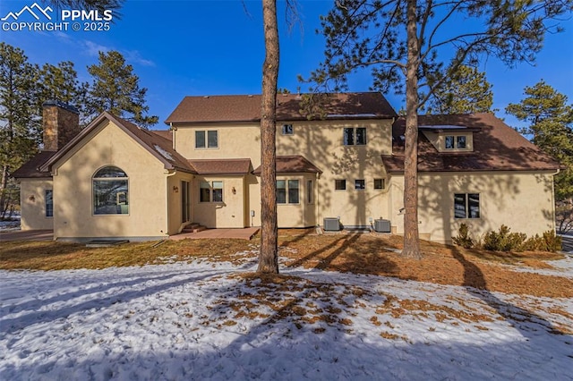 snow covered house with central AC unit