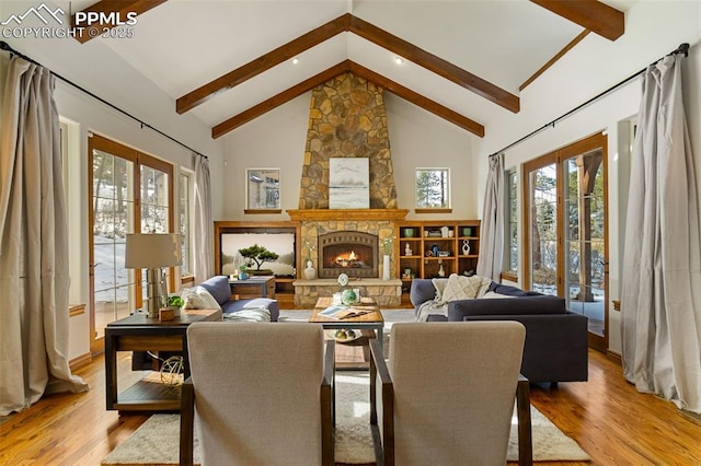 living room with a stone fireplace, high vaulted ceiling, french doors, and light wood-type flooring