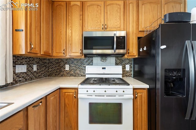 kitchen featuring white gas stove, tasteful backsplash, and black fridge with ice dispenser