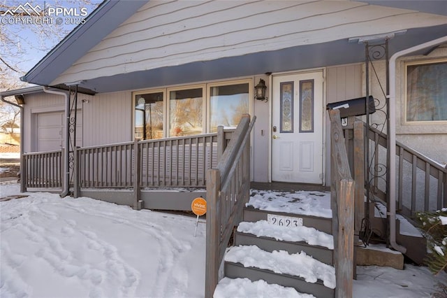 snow covered property entrance featuring a porch