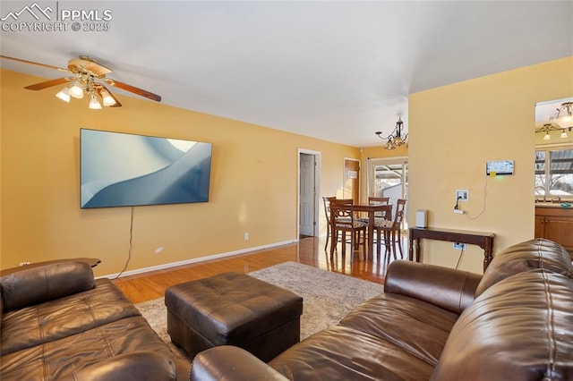 living room featuring sink, ceiling fan with notable chandelier, and light hardwood / wood-style flooring