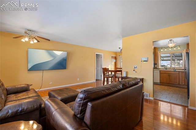 living room with ceiling fan, sink, and hardwood / wood-style floors