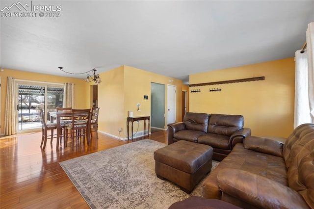 living room with light hardwood / wood-style flooring and a notable chandelier